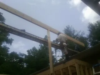 Carpenter setting a ridge beam over a new addition frame — Ice Dam Removal by Roofing Brothers in Powder Springs