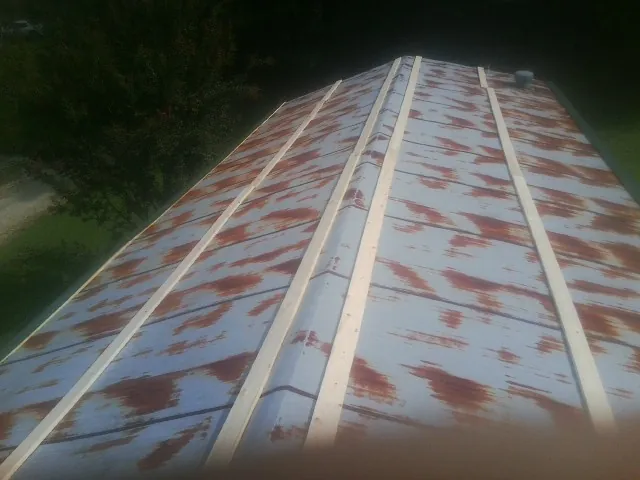 Rusted metal roof panels with new wood purlins before replacement — Storm Damage Roof Repair in Powder Springs by Roofing Brothers