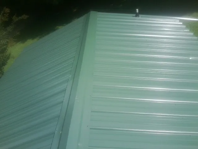New green metal panels meeting at the ridge of a roof in Powder Springs