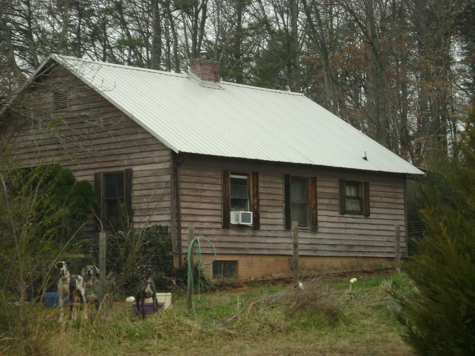 White metal roof on an old wood sided farmhouse, from a Metal Roof Installation job in Powder Springs